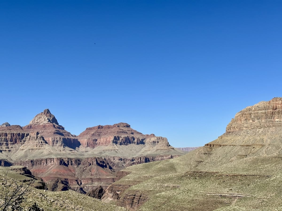 Scenic view of the Grand Canyon with layered rock formations and a clear blue sky.