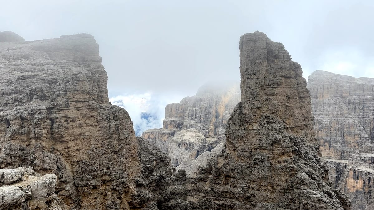 Jagged rock peaks with mist on the Alta Via 2 in the Dolomites.