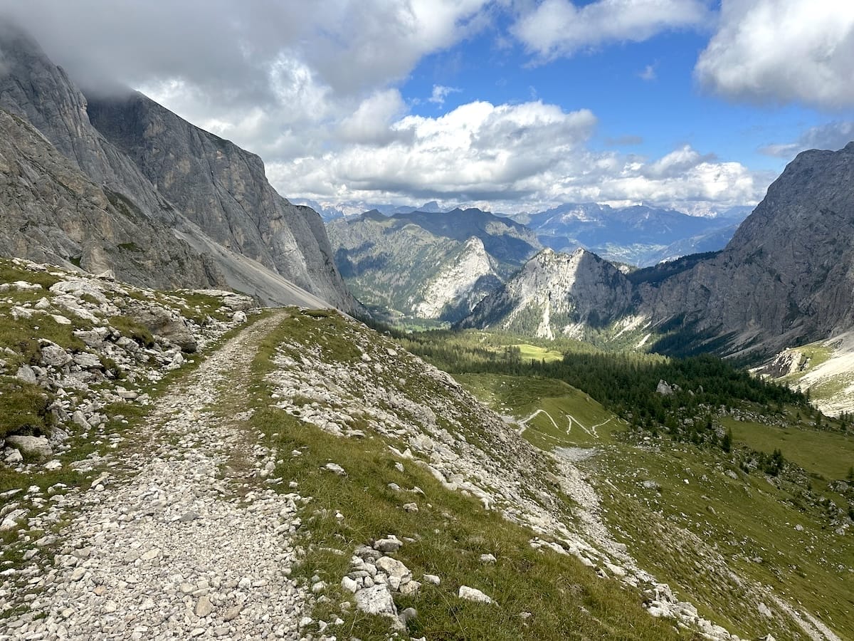 Trail view from the east side of Forca Rossa on the Alta Via 2 with mountains and valley.