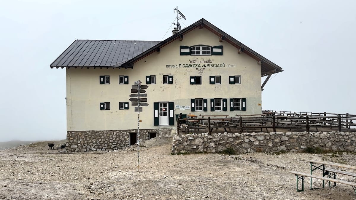 Rifugio Pisciadu, a mountain hut along the Alta Via 2 trail, with a cloudy sky.
