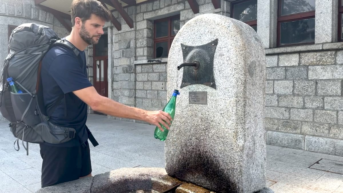 Alta Via 2 hiker refilling bottle at Bressanone train station.