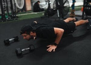 Pushup exercise with dumbbells in a Crossfit gym setting.