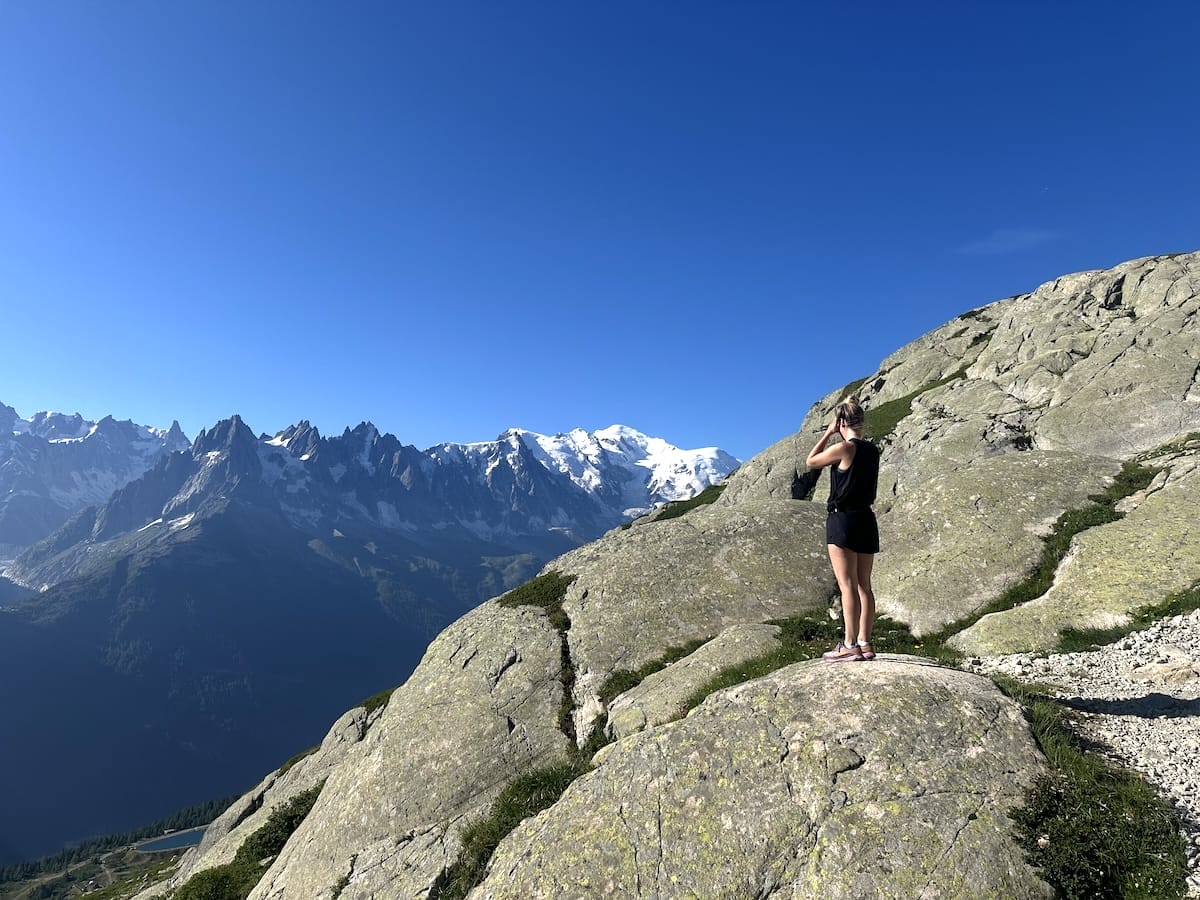 Hiker on the trail to Lac Blanc stopping to take a photo of Mont Blanc.