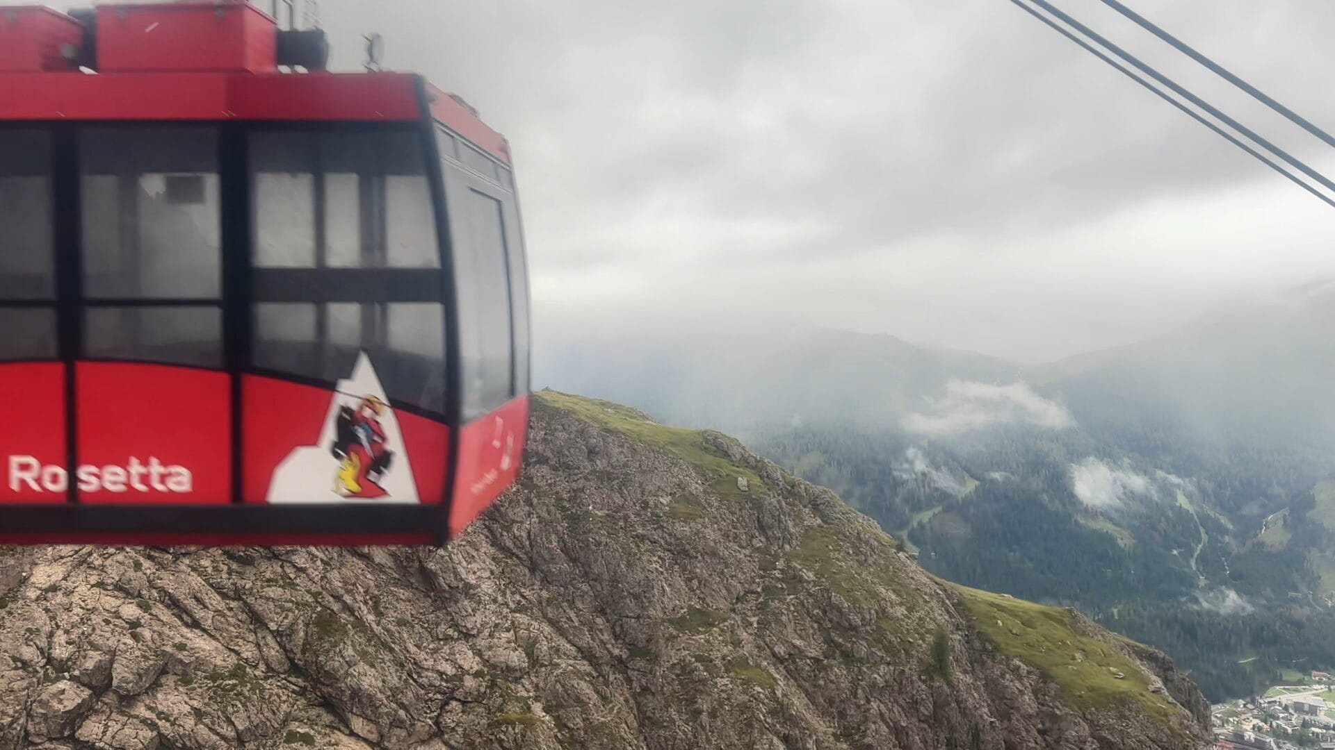 Red cable car ascending to Rifugio Rosetta in the Dolomites.